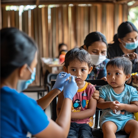 Healthcare worker administering vaccination to children during a Kurapati Healthcare Foundation pediatric health camp
